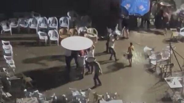 İzmir’de düğündeki bir grup, şiddetli yağmura rağmen masanın altında oynamayı sürdürdü - Sputnik Türkiye