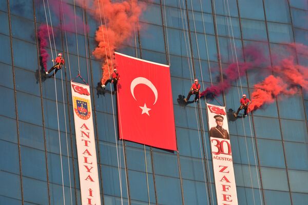 Antalya JAK Timi 30 Ağustos Zafer Bayramı kutlamaları kapsamında kent merkezindeki bir alışveriş merkezinin çatısından halatla sarkarak Türk bayrağı açtı. - Sputnik Türkiye