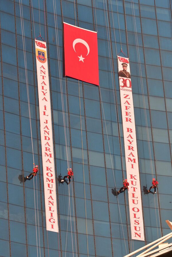Bayrakla fotoğraf çektiren JAK timinin halatla aşağıya inmesinin ardından gösteri son buldu. - Sputnik Türkiye