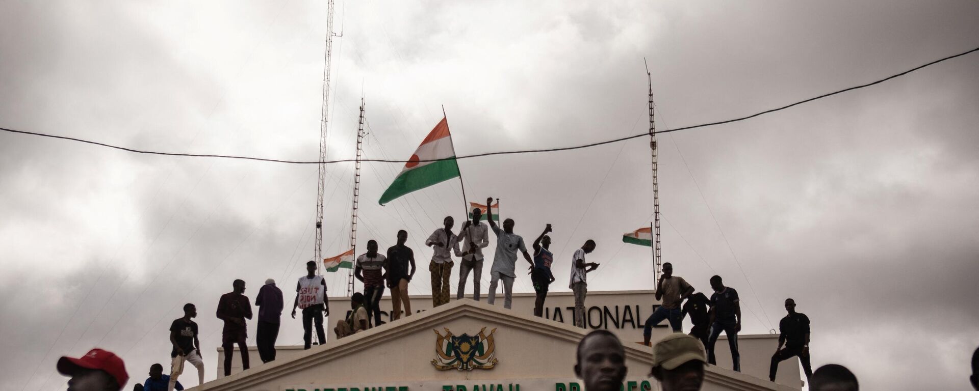 Protesters hold a Niger flag during a demonstration on independence day in Niamey on August 3, 2023. Hundreds of people backing the coup in Niger gathered on August 3, 2023 for a mass rally in the capital Niamey with some brandishing giant Russian flags. - Sputnik Türkiye, 1920, 31.08.2023
