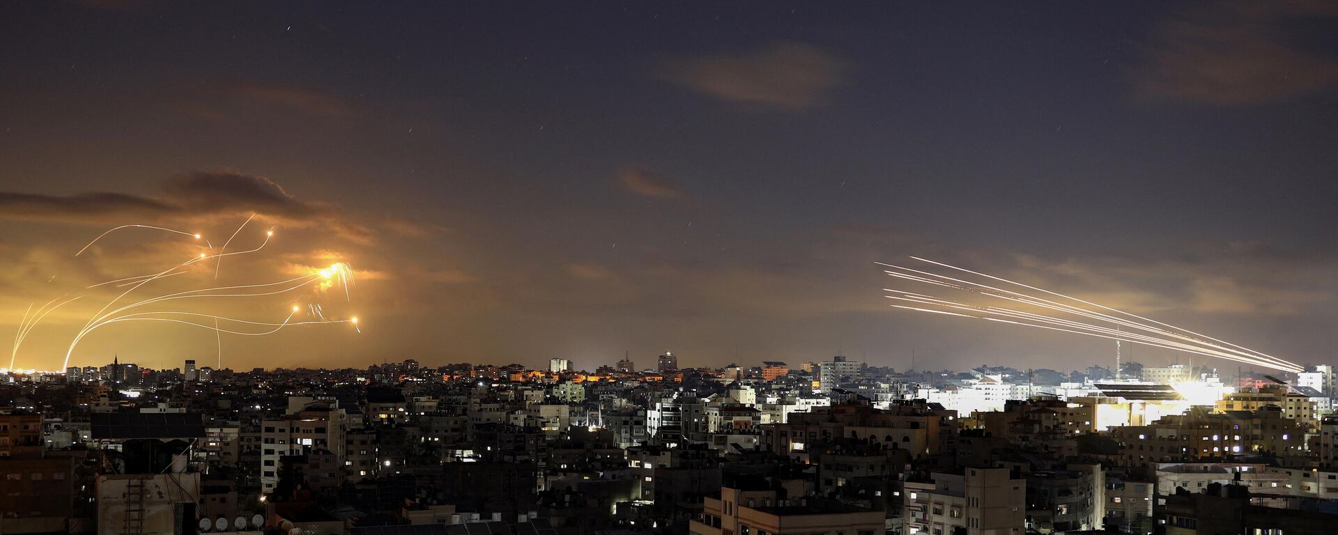 Rockets fired from the Gaza City (R) being intercepted by Israel's Iron Dome defence missile system (L) on October 10, 2023.  - Sputnik Türkiye, 1920, 11.10.2023