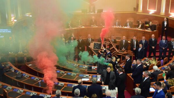 Arnavutluk Meclisi'nde muhalefet milletvekilleri, ülkenin 2024 bütçesinin ele alındığı oturumda görüşmeleri engelledi. Muhalefet milletvekilleri sandalyeleri kürsünün önüne yerleştirip sis bombası attı. - Sputnik Türkiye