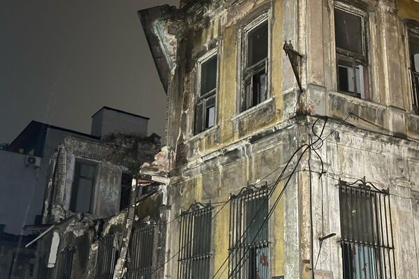 Fatih'te üç katlı metruk bir binada yoğun yağış nedeniyle kısmi çökme meydana gelirken, binadan düşen parçalar yola savruldu. - Sputnik Türkiye