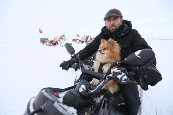 Bölgeye gelen turistler, gölün buzlu yüzeyinde atlı kızak ve kar motorlarıyla gezinti yaptı. Bir vatandaş da &quot;Herkül&quot; adını verdiği süs köpeğiyle kar motoru üzerinde bölgede tur attı. - Sputnik Türkiye