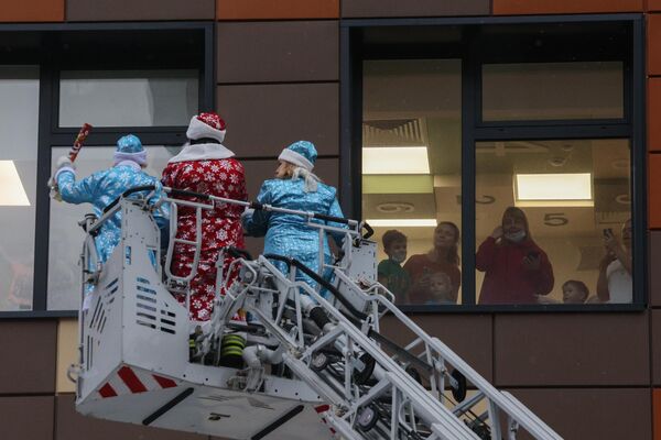 Noel Baba kostümleriyle gelen itfaiyeciler ve gönüllüler, hastanenin atmosferine neşe ve umut katarak, çocuklara moral verdi. - Sputnik Türkiye