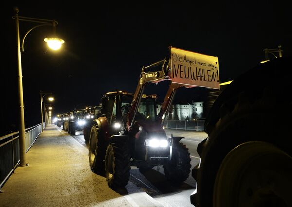 Başkent Berlin&#x27;e traktörleriyle gelen çiftçiler ve tır şoförleri, Brandenburg kapısı önünde toplanarak konvoy oluştururken aralarında Mecklenburg-Vorpommern, Bavyera, Rheinland-Pflaz, Saksonya, Brandenburg&#x27;un da bulunduğu çok sayıda eyalette traktörler ve tırlarla otoyol girişlerini kapattı.  - Sputnik Türkiye