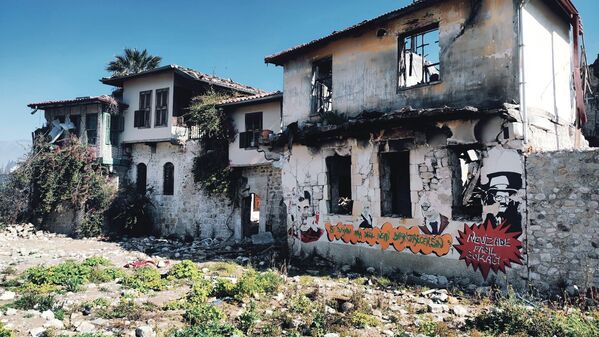 Deprem öncesinde kafe olarak kullanılan binalardaki grafitiler de mesaj içeriyor. - Sputnik Türkiye