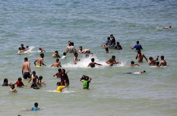 Sıcak havalardan bunalan Filistinliler, Deyr Balah'ın sahil bölgesinde denize girerek serinlemeye çalıştı - Sputnik Türkiye