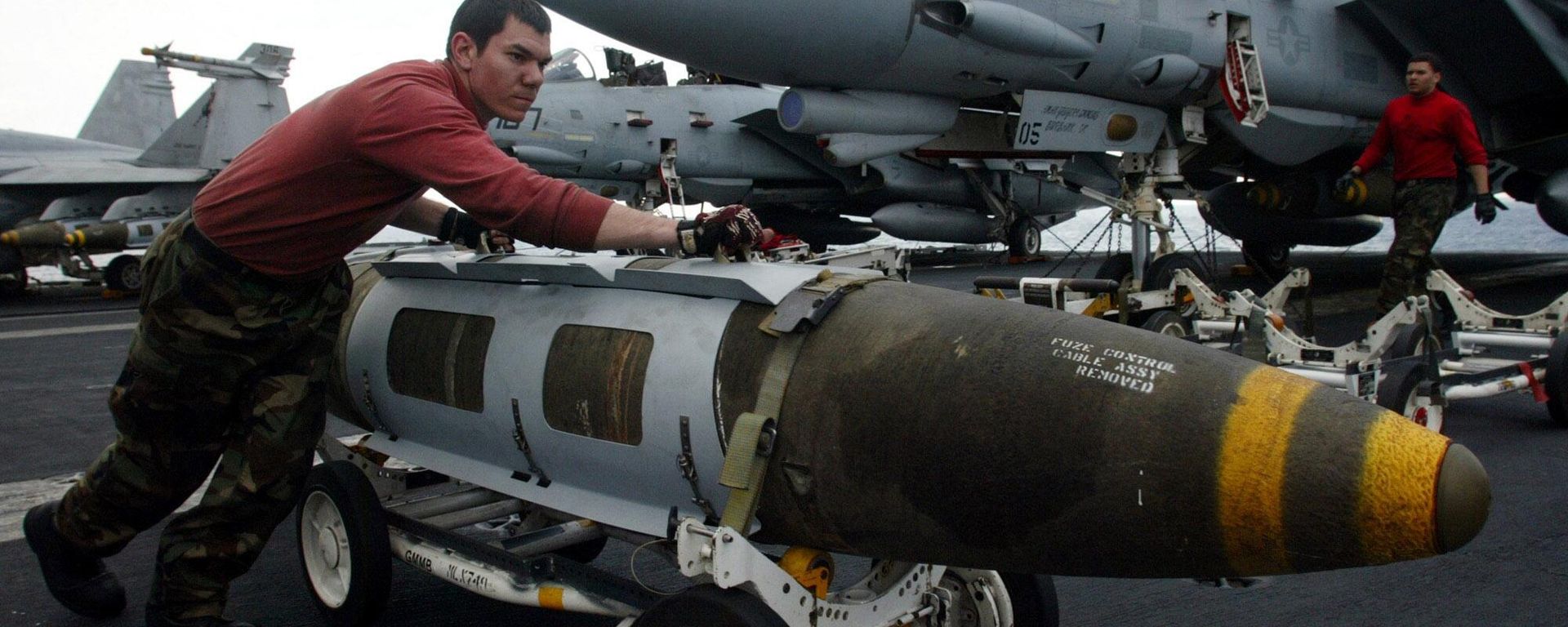 An Ordnance pushes a satellite-guided 2000 pound JDAM ( Joint Direct Attac Munitions)  bomb in front of a F-14 Tomcat on the flight deck of the USS Harry S. Truman prior to a strike against Iraq Friday, March 21, 2003 - Sputnik Türkiye, 1920, 03.08.2026