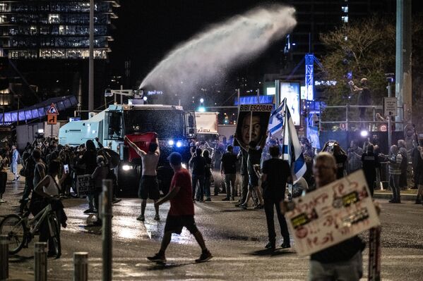 İsrail bayrakları taşıyan binlerce protestocu, Başbakan Netanyahu ve hükümetindeki siyasetçiler aleyhinde pankart, afiş ve dövizler taşıdı, caddede kurulan platformda hükümeti eleştiren konuşmalar yapıldı. - Sputnik Türkiye