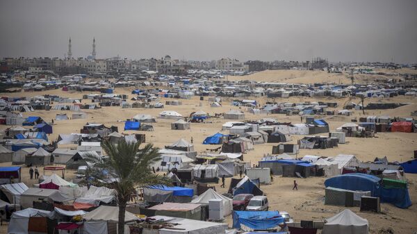 Palestinians displaced by the Israeli air and ground offensive on the Gaza Strip walk through a makeshift tent camp in Rafah, Gaza, Friday, May 10, 2024. (AP Photo/Abdel Kareem Hana) - Sputnik Türkiye