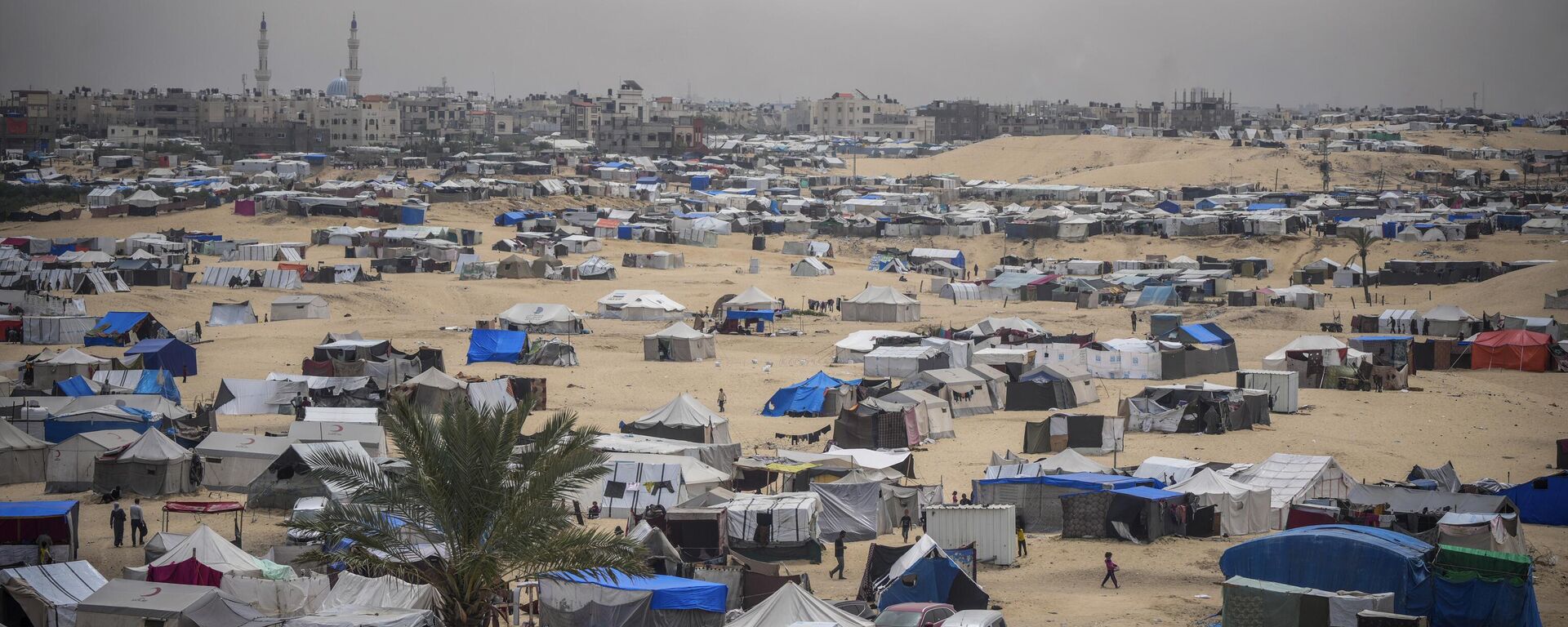 Palestinians displaced by the Israeli air and ground offensive on the Gaza Strip walk through a makeshift tent camp in Rafah, Gaza, Friday, May 10, 2024. (AP Photo/Abdel Kareem Hana) - Sputnik Türkiye, 1920, 28.05.2024