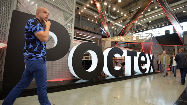 A visitor walks past Rostec's stand at the attends the Innoprom International Industrial Fair, in Yekaterinburg, Russia - Sputnik Türkiye