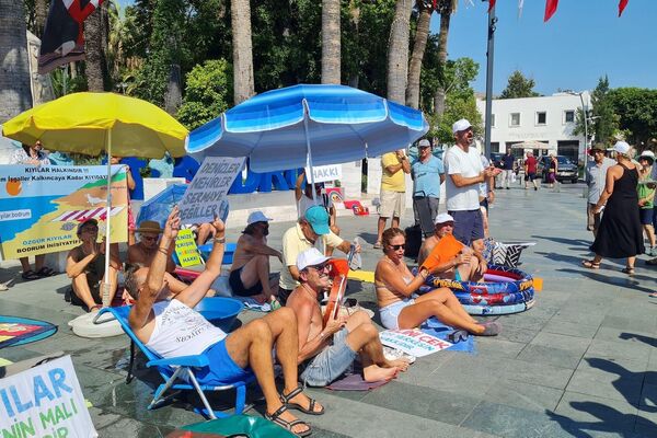 Muğla’nın Bodrum ilçesinin kent meydanında bir araya gelen vatandaşlar, kıyı işgallerine karşı renkli bir eylem gerçekleştirdi. Şemsiyelerini, havlularını ve şişme havuzlarını alıp meydana gelenler, yetkililere seslerini duyurmaya çalıştı. - Sputnik Türkiye