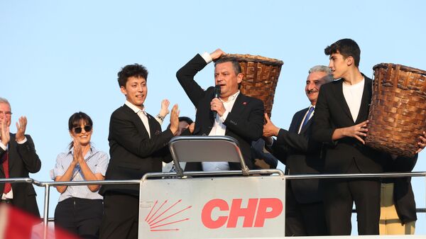 CHP Genel Başkanı Özgür Özel, Bursa'da Mütareke Meydanı'ndaki parti otobüsü üzerinden vatandaşlara hitap etti. Özel, konuşması esnasında sırtına küfe aldı - Sputnik Türkiye