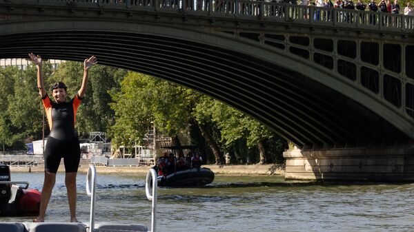 Paris Mayor Anne Hidalgo waves before swimming in the Seine, in Paris on July 17, 2024, to demonstrate that the river is clean enough to host the outdoor swimming events at the Paris Olympics later this month. Despite an investment of 1.4 billion euros ($1.5 billion) to prevent sewage leaks into the waterway, the Seine has been causing suspense in the run-up to the opening of the Paris Games on July 26 after repeatedly failing water quality tests. - Sputnik Türkiye