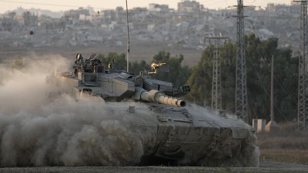 With destroyed buildings in the Gaza Strip behind him, an Israeli soldier waves from a tank, near the Israel-Gaza border in southern Israel, Thursday, Aug. 1, 2024.  - Sputnik Türkiye