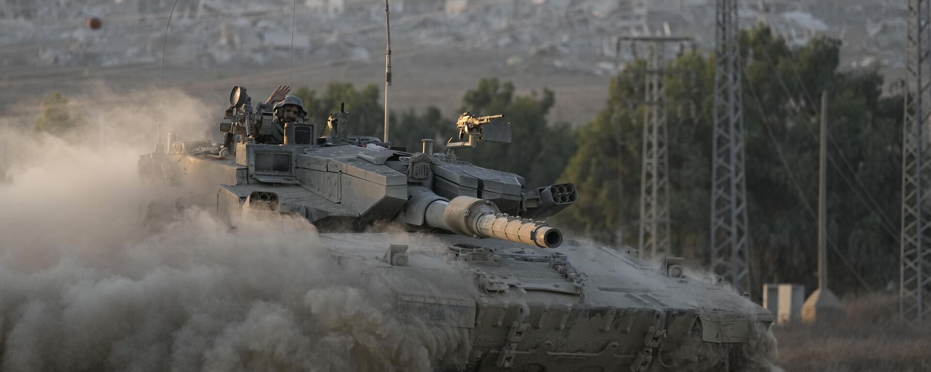 With destroyed buildings in the Gaza Strip behind him, an Israeli soldier waves from a tank, near the Israel-Gaza border in southern Israel, Thursday, Aug. 1, 2024.  - Sputnik Türkiye, 1920, 16.08.2024