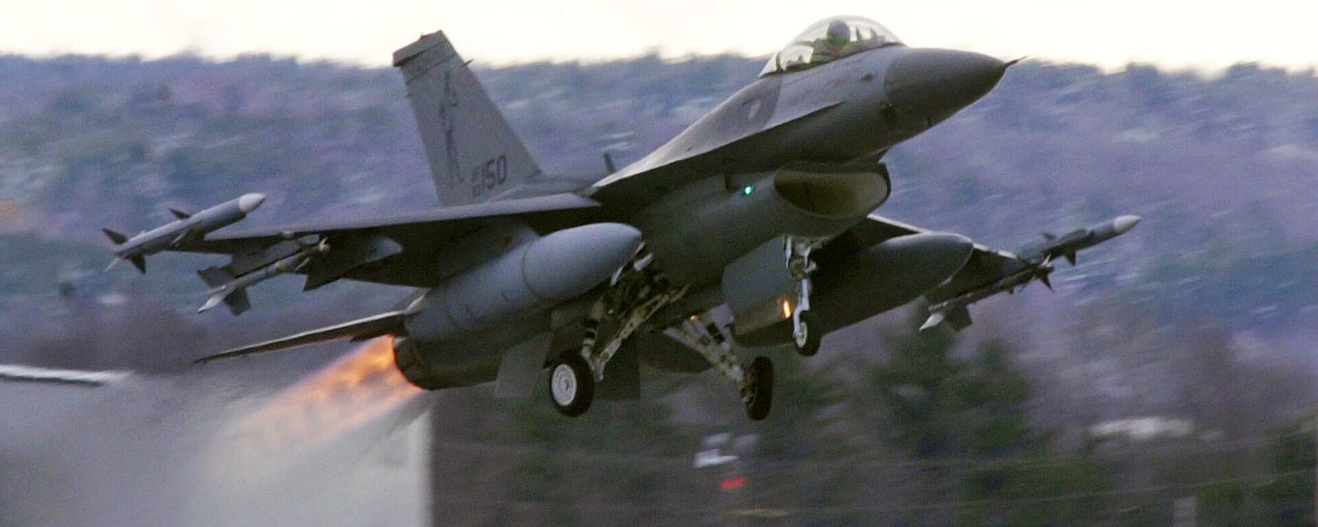 In this Dec. 2001 file photograph, an F-16 takes off with afterburners glowing loaded with live Sidewinder missiles from the Air National Guard base in South Burlington, Vt. - Sputnik Türkiye, 1920, 29.08.2024