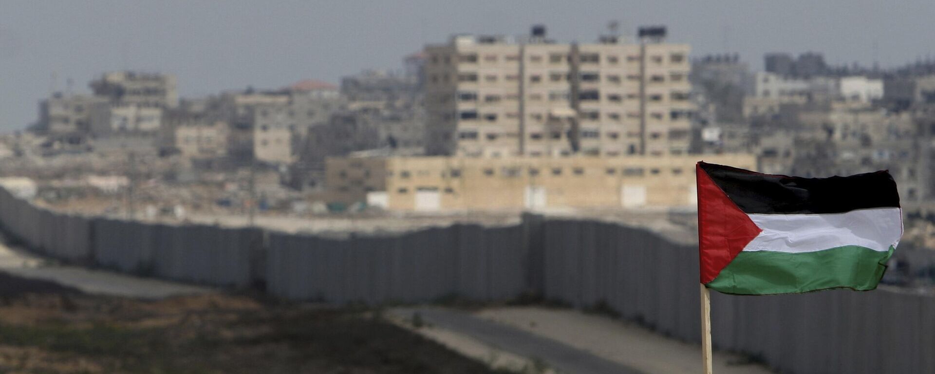 FILE - A Palestinian flag is seen with the background of a section of the wall in the Philadelphi corridor between Egypt and Gaza, on the background, near the southern Gaza Strip town of Rafah. - Sputnik Türkiye, 1920, 01.09.2024