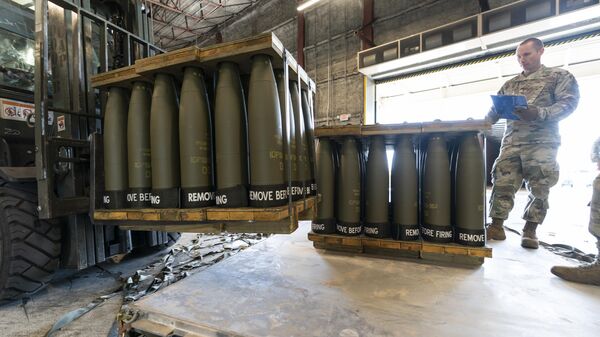 U.S. Air Force Staff Sgt. Cody Brown, right, with the 436th Aerial Port Squadron, checks pallets of 155 mm shells ultimately bound for Ukraine, April 29, 2022, at Dover Air Force Base, Del.  - Sputnik Türkiye