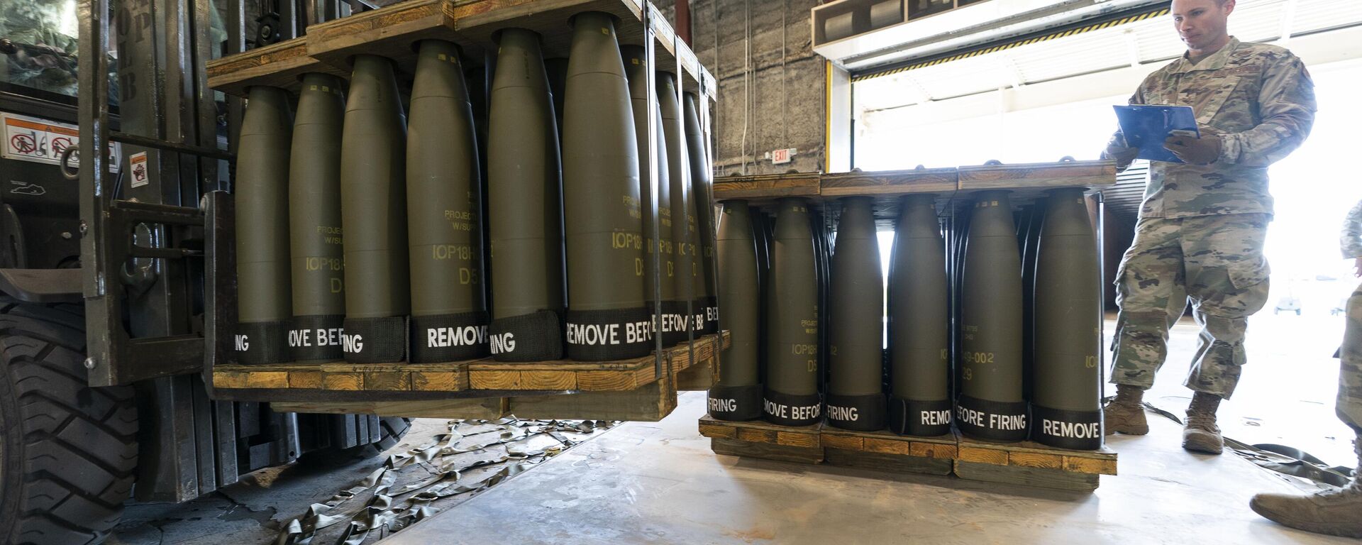 U.S. Air Force Staff Sgt. Cody Brown, right, with the 436th Aerial Port Squadron, checks pallets of 155 mm shells ultimately bound for Ukraine, April 29, 2022, at Dover Air Force Base, Del.  - Sputnik Türkiye, 1920, 14.09.2024