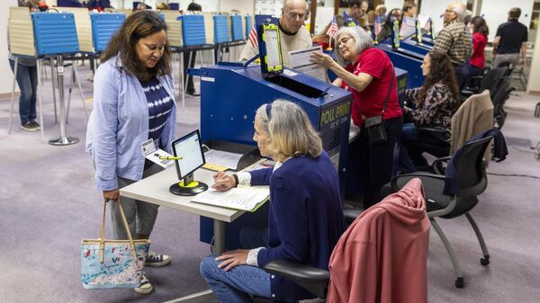 epa11615873 Fairfax County voters check in before voting in the 2024 Presidential election at the Fairfax County Government Center polling place in Fairfax, Virginia, USA, 20 September 2024. Early in-person voting sites opened throughout Virginia on 20 September making it the first state to offer their voters that option.  EPA-EFE/SHAWN THEW - Sputnik Türkiye