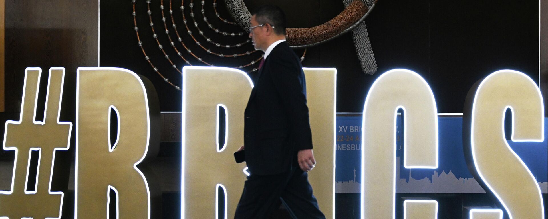 Учавстник бизнес-форума проходит мимо логотипа саммита БРИКС в ЮАР - Sputnik Türkiye, 1920, 11.11.2024