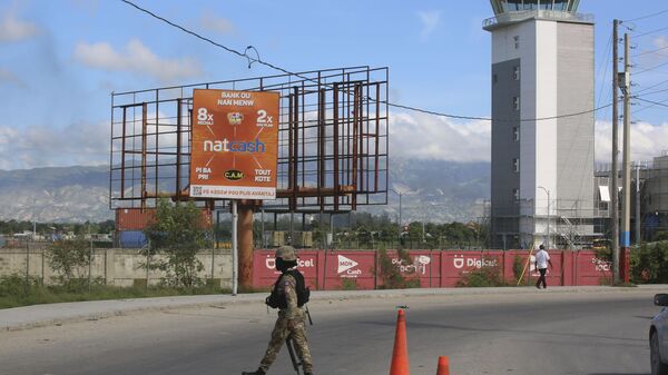 A police officer patrols the entrance of the Toussaint Louverture International Airport, in Port-au-Prince, Haiti, Tuesday, Nov. 12, 2024. (AP Photo/Odelyn Joseph) - Sputnik Türkiye