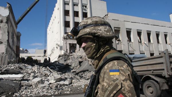 A Ukrainian serviceman guards next to the site of the National Academy of State Administration building damaged by shelling in Kharkiv, Ukraine, Friday, March 18, 2022. (AP Photo/Andrew Marienko) - Sputnik Türkiye