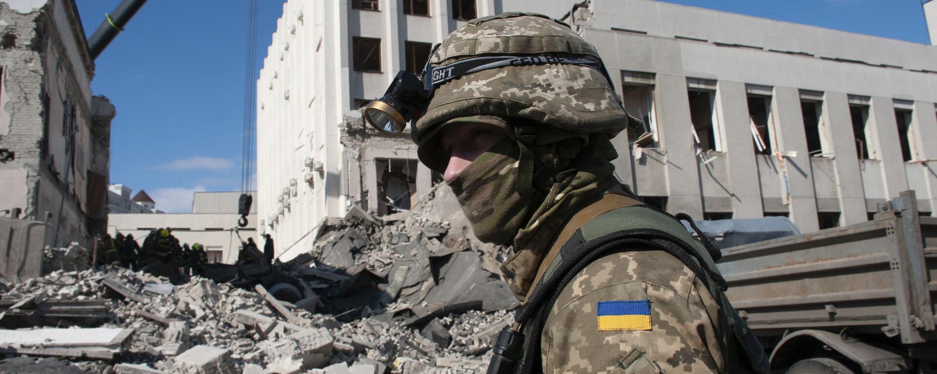 A Ukrainian serviceman guards next to the site of the National Academy of State Administration building damaged by shelling in Kharkiv, Ukraine, Friday, March 18, 2022. (AP Photo/Andrew Marienko) - Sputnik Türkiye, 1920, 13.11.2024