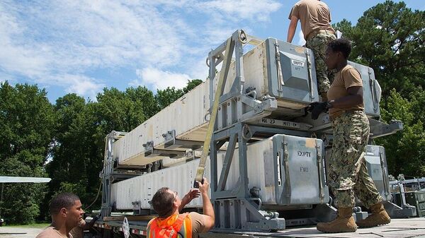 Militares estadounidenses descargan desde un avión de transporte contenedores con misiles de crucero Tomahawk - Sputnik Türkiye