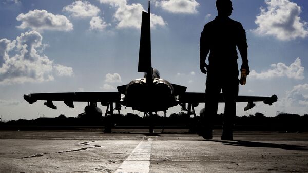 This photo taken on September 22, 2016 shows a British soldier walking by a Eurofighter Typhoon fighter jet at Royal Air Force's Akrotiri base in Cyprus, before taking off for a coalition mission over Iraq.  - Sputnik Türkiye