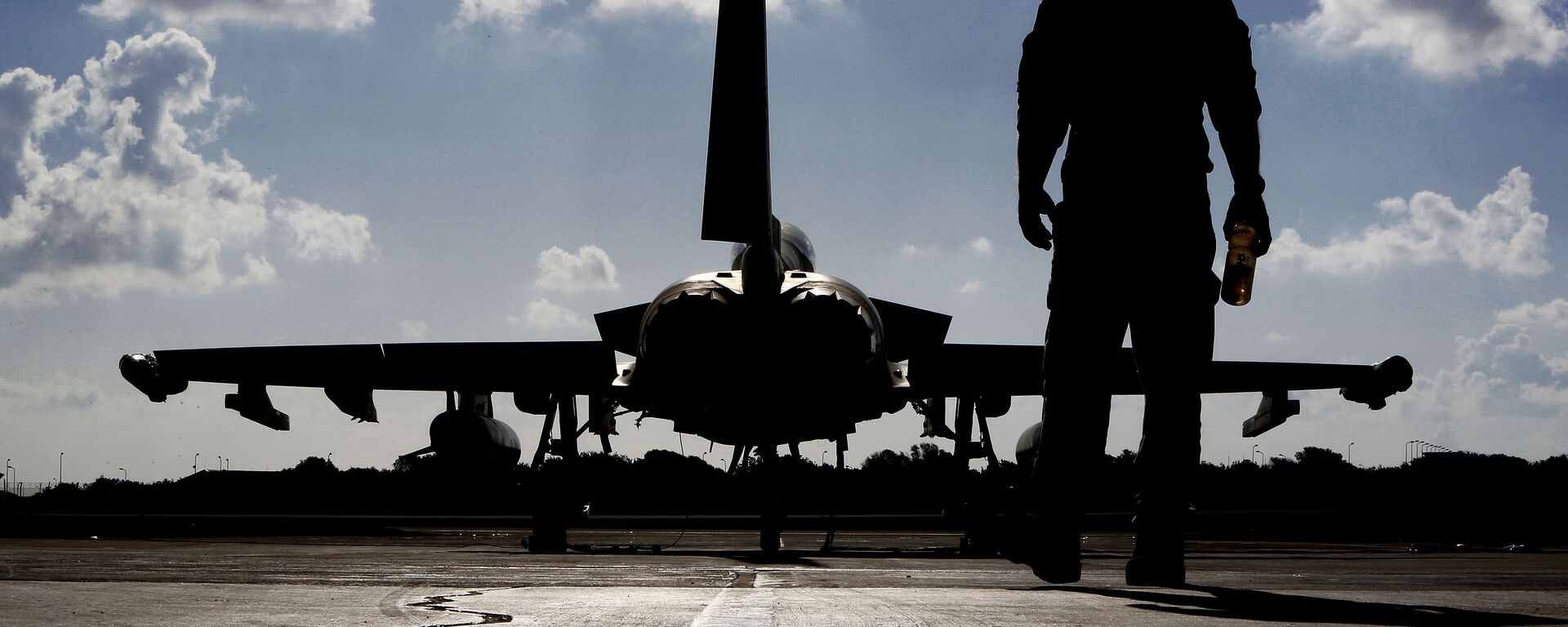 This photo taken on September 22, 2016 shows a British soldier walking by a Eurofighter Typhoon fighter jet at Royal Air Force's Akrotiri base in Cyprus, before taking off for a coalition mission over Iraq.  - Sputnik Türkiye, 1920, 25.11.2024