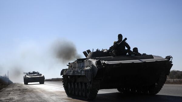 Syrian opposition fighters drive a seized seized Syrian army armoured vehicle near the town of Khan Assubul, Syria, southwest of Aleppo, Sunday, Dec. 1, 2024. Syrian opposition insurgency launched a campaign on Wednesday with a two-pronged attack on Aleppo and the countryside around Idlib.(AP Photo/Ghaith Alsayed) - Sputnik Türkiye