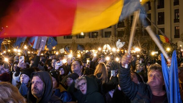 People hold mobile phones with flashlights during a pro-European rally ahead of the countries Dec. 8 runoff presidential elections in Bucharest, Romania, Thursday, Dec. 5, 2024. (AP Photo/Vadim Ghirda) - Sputnik Türkiye