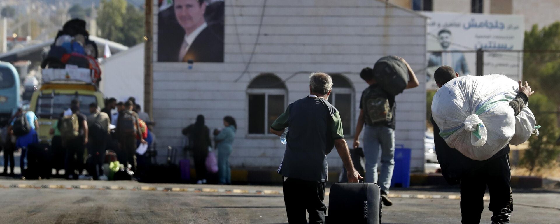 Syrians who fled the war in Lebanon carry their belongings as they arrive at the Syrian border crossing point, in Jdeidet Yabous, Syria, Monday, Oct. 7, 2024. (AP Photo/Omar Sanadiki) - Sputnik Türkiye, 1920, 08.12.2024