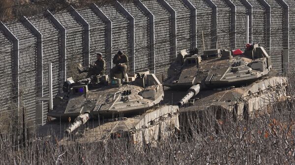 Israeli soldiers sit on top of a tank along the so-called Alpha Line that separates the Israeli-annexed Golan Heights from Syria, in the town of Majdal Shams, Monday, Dec. 9, 2024. (AP Photo/Matias Delacroix) - Sputnik Türkiye