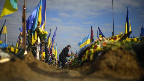 Olga places flowers on the grave of a relative recently killed on military duty, in a cemetery during Ukraine Defenders Day in Kharkiv, Ukraine, Friday, Oct. 14, 2022. (AP Photo/Francisco Seco) - Sputnik Türkiye