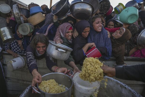 İsrail ordusunun, Gazze Şeridi&#x27;nin Han Yunus kentine düzenlediği saldırıları devam ederken kadınlar ve çocuklar yiyeceğe ulaşmak için mücadele ediyor. Fotoğraf, 6 Aralık&#x27;ta bir yiyecek dağıtım merkezinde yemeğe erişim çabalarını gösteriyor. - Sputnik Türkiye