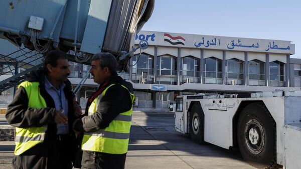 Ground personnel stand in the tarmac as the airport reopens for internal flights in Damascus, Syria, Wednesday, Dec. 18, 2024.  - Sputnik Türkiye