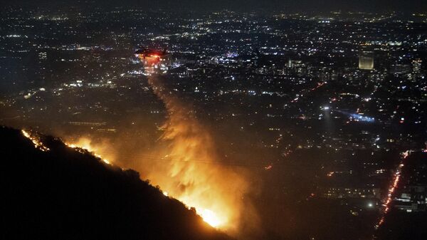 Water is dropped by helicopter on the burning Sunset Fire in the Hollywood Hills section of Los Angeles, Wednesday, Jan. 8, 2025. - Sputnik Türkiye