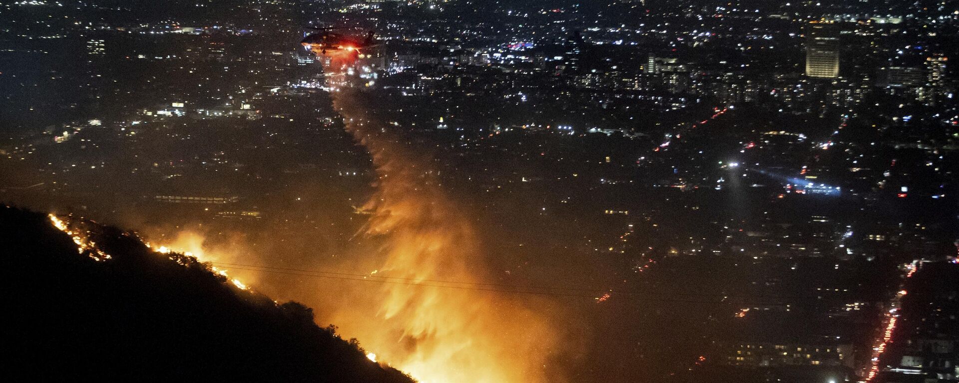 Water is dropped by helicopter on the burning Sunset Fire in the Hollywood Hills section of Los Angeles, Wednesday, Jan. 8, 2025. - Sputnik Türkiye, 1920, 11.01.2025