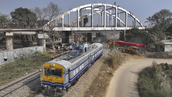 A crew inspects overhead power cables meant for railway engines as others work on an overhead bridge in preparation for the upcoming Maha Kumbh Mela, one of the world's largest religious festivals, in Prayagraj, India, Tuesday, Nov. 26, 2024. (AP Photo/Rajesh Kumar Singh) - Sputnik Türkiye