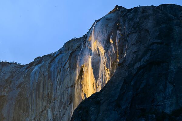 “Firefall” (Alev Şelalesi) olarak bilinen bu doğa olayı, gün batımında güneş ışınlarının belirli bir açıyla şelaleye vurmasıyla gerçekleşiyor. Su damlaları, gökyüzünün kızıllığını yansıtarak adeta lav akıntısı gibi parlıyor. - Sputnik Türkiye