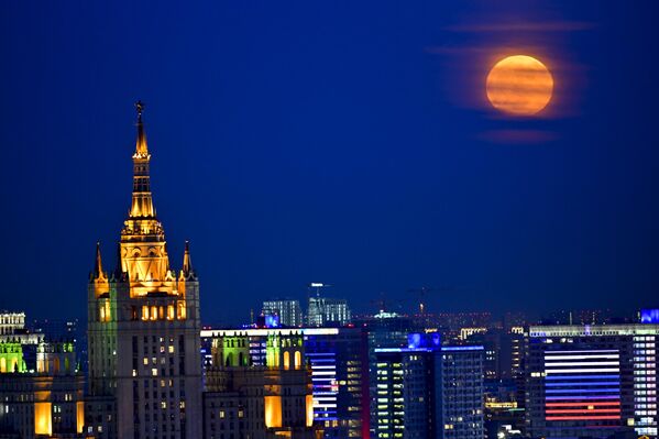 Rusya&#x27;nın başkenti Moskova&#x27;da beliren dolunay, şehrin ışıklarıyla güzel görüntü oluşturdu. - Sputnik Türkiye