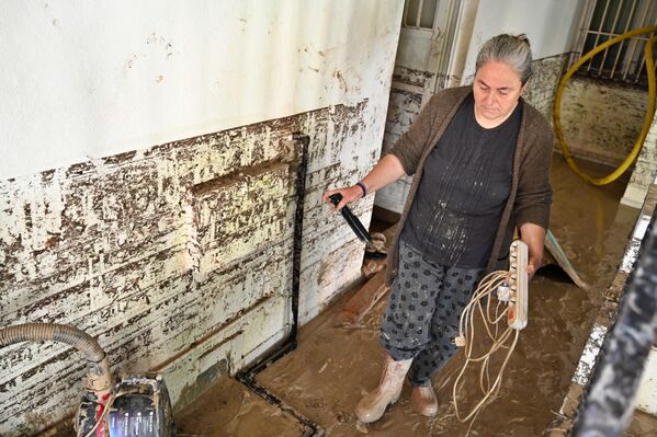 Evleri su ve balçık altında kalan insanlar, kurtarabildikleri eşyalarını evlerinden çıkararak temizlemeye çalıştı. - Sputnik Türkiye