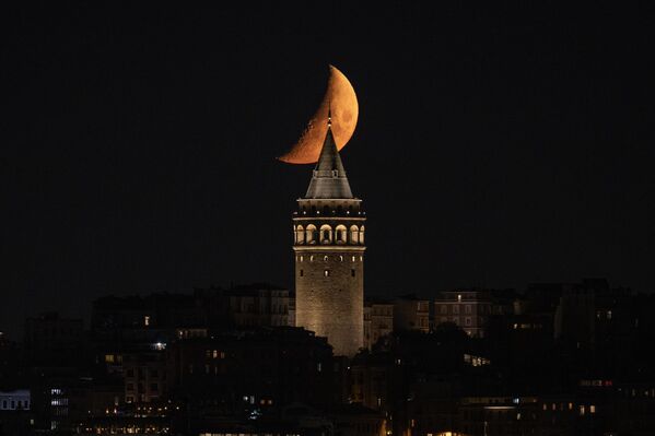 İstanbul'da akşam saatlerinde gökyüzünde beliren yarım ay tarihi Galata kulesi ile birlikte güzel görüntülere sahne oldu. İstanbul'da akşam saatlerinde gökyüzünde beliren yarım ay tarihi Galata kulesi ile birlikte güzel görüntülere sahne oldu. - Sputnik Türkiye