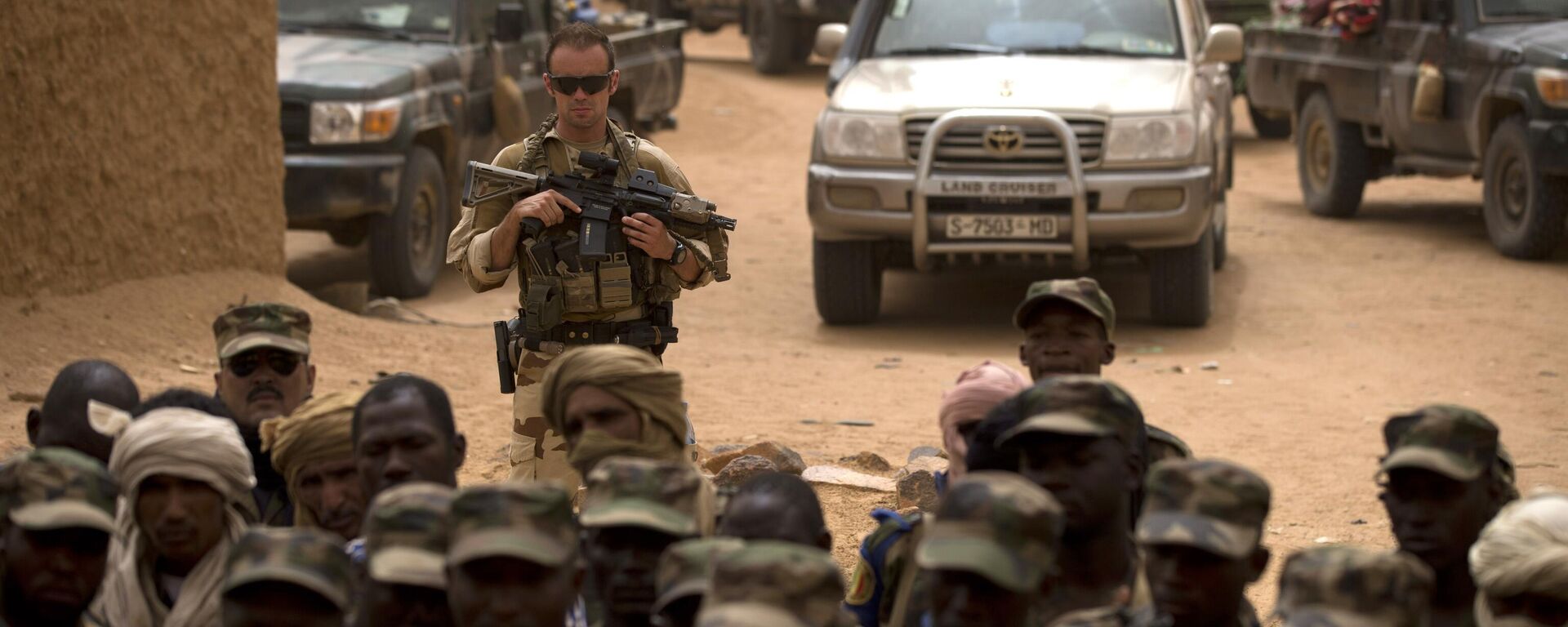 In this July 27, 2013 file photo, a French soldier stands watch behind Malian soldiers during a visit by the head of France's Operation Serval and Mali's army chief of staff to a Malian army base in Kidal, Mali. - Sputnik Türkiye, 1920, 05.06.2025