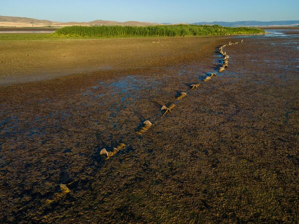 Gölün üzerindeki iki ada, azalan su sayesinde kara ile birleşerek doğal yapısında önemli değişikliklere neden oldu. - Sputnik Türkiye